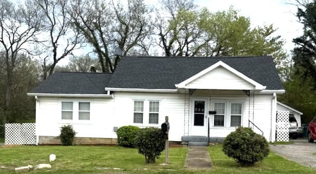 view of front of property with a front yard and roof with shingles