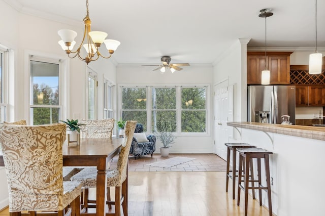 2728 Brown Hollow Rd, Columbia, TN 38401 - dining space featuring light wood-type flooring, ornamental molding, ceiling fan with notable chandelier, and baseboards