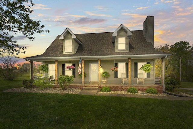 farmhouse with a yard, a porch, a chimney, and a shingled roof