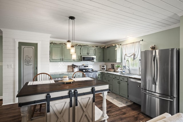 kitchen with green cabinetry, appliances with stainless steel finishes, a sink, and dark wood-style flooring