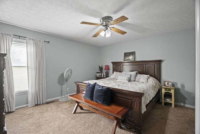 bedroom featuring ceiling fan, a textured ceiling, baseboards, and light carpet