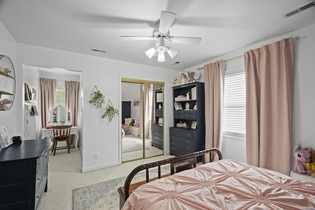 bedroom featuring a ceiling fan, visible vents, a closet, and light colored carpet