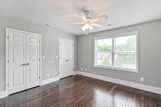 434 Caldwell Dr, Columbia, TN 38401 - unfurnished bedroom with multiple closets, baseboards, dark wood-style floors, and ceiling fan