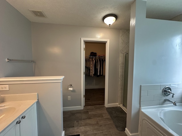 8257 Ramstone Way, Antioch, TN 37013 - bathroom featuring a stall shower, a garden tub, a spacious closet, and wood tiled floor