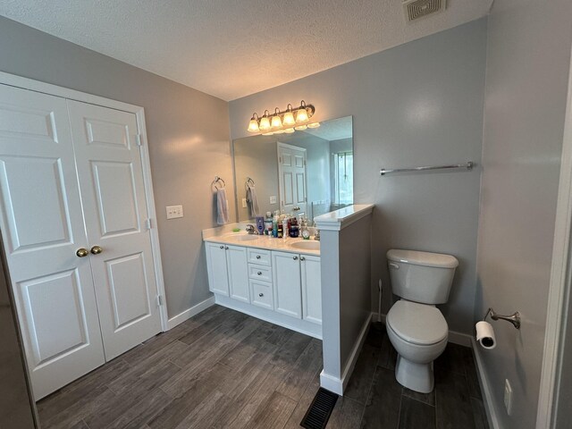 8257 Ramstone Way, Antioch, TN 37013 - full bathroom with visible vents, a sink, toilet, double vanity, and wood finished floors