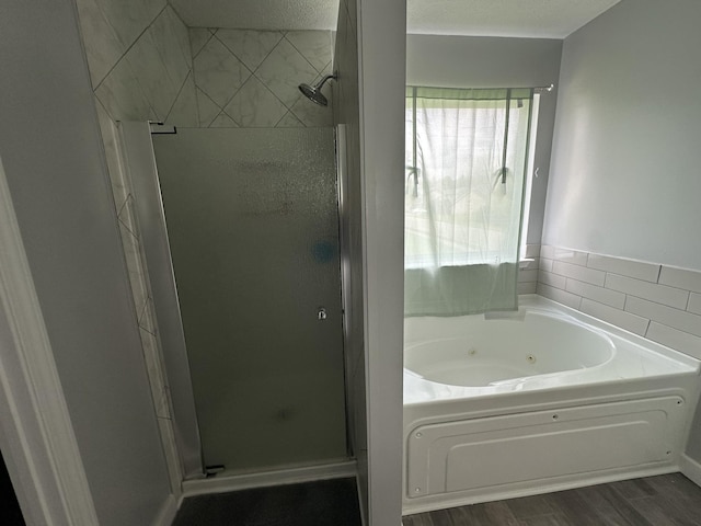 8257 Ramstone Way, Antioch, TN 37013 - full bathroom featuring a shower stall, a jetted tub, and wood finished floors