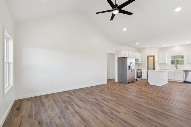 unfurnished living room with ceiling fan, high vaulted ceiling, light wood-style flooring, recessed lighting, and visible vents