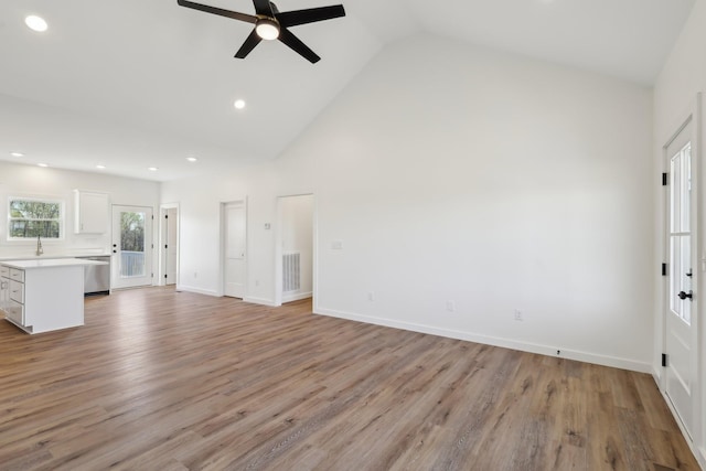 unfurnished living room featuring baseboards, ceiling fan, high vaulted ceiling, recessed lighting, and light wood finished floors
