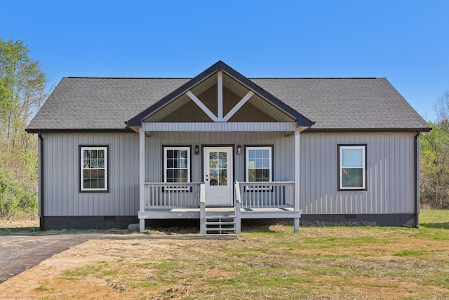 view of front facade with a porch, a shingled roof, and crawl space