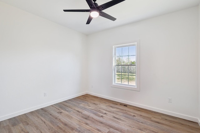 unfurnished room featuring baseboards, a ceiling fan, wood finished floors, and visible vents