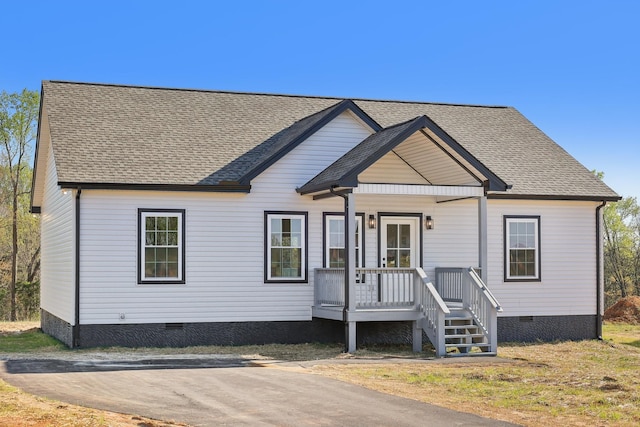 view of front of home featuring a shingled roof, covered porch, and crawl space