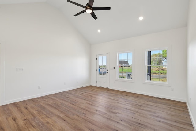 spare room with visible vents, a ceiling fan, wood finished floors, and high vaulted ceiling