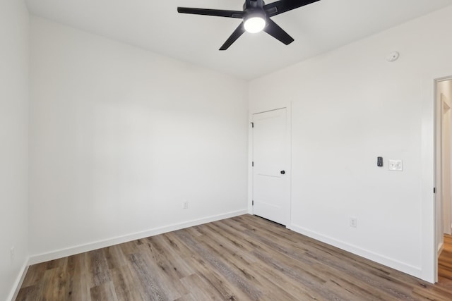 empty room featuring baseboards, ceiling fan, and wood finished floors