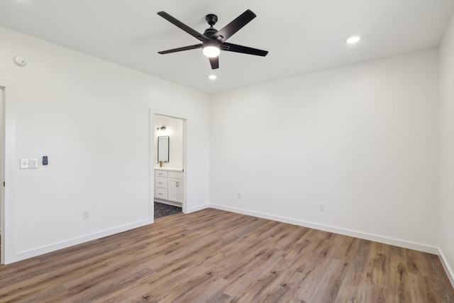unfurnished bedroom featuring light wood-type flooring, recessed lighting, baseboards, and connected bathroom