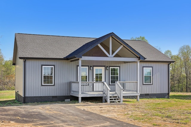 modern farmhouse featuring covered porch, crawl space, and a shingled roof