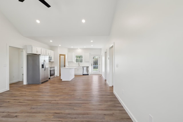 kitchen featuring light wood-style floors, open floor plan, appliances with stainless steel finishes, and white cabinets