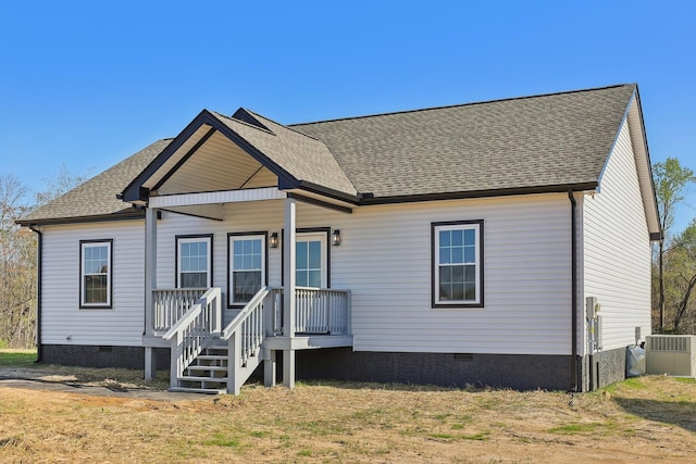 rear view of house with a shingled roof and crawl space