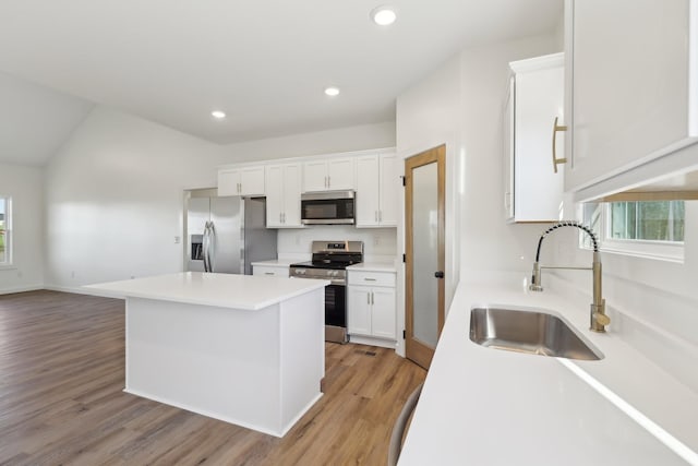 kitchen featuring a sink, white cabinetry, appliances with stainless steel finishes, and a kitchen island