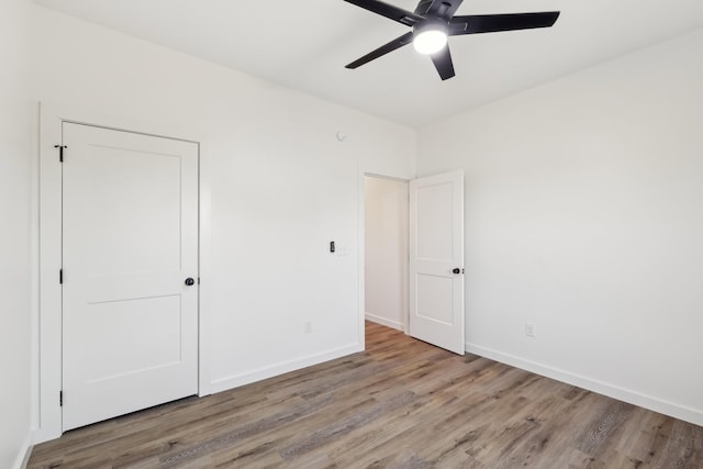 unfurnished bedroom with baseboards, a ceiling fan, and wood finished floors