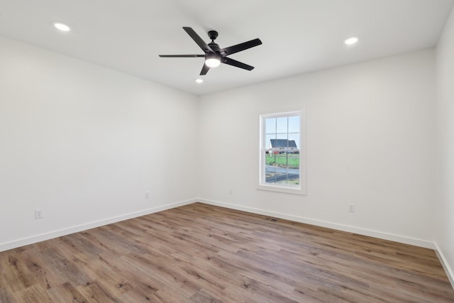 empty room with a ceiling fan, baseboards, recessed lighting, wood finished floors, and visible vents