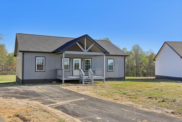 view of front of property featuring a shingled roof, covered porch, and crawl space