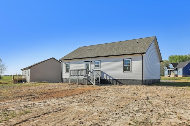 rear view of property featuring crawl space, a wooden deck, and roof with shingles