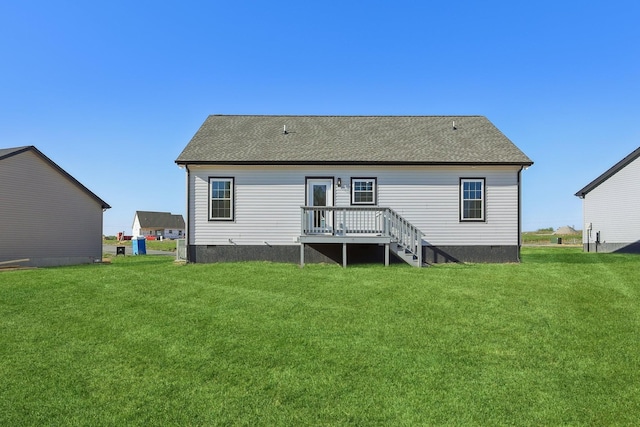 rear view of house featuring a lawn, a shingled roof, a wooden deck, and crawl space