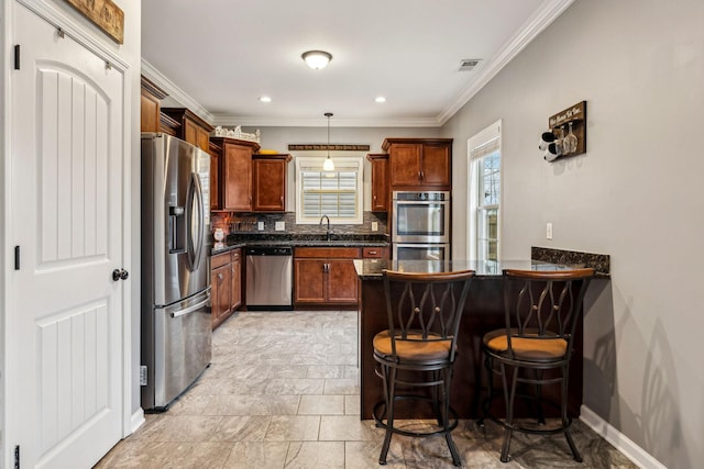 1328 Winterset Dr, Clarksville, TN 37040 - kitchen featuring appliances with stainless steel finishes, a sink, a peninsula, backsplash, and a kitchen bar