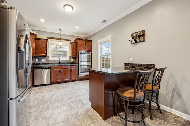 1328 Winterset Dr, Clarksville, TN 37040 - kitchen featuring appliances with stainless steel finishes, a peninsula, ornamental molding, a breakfast bar area, and a sink