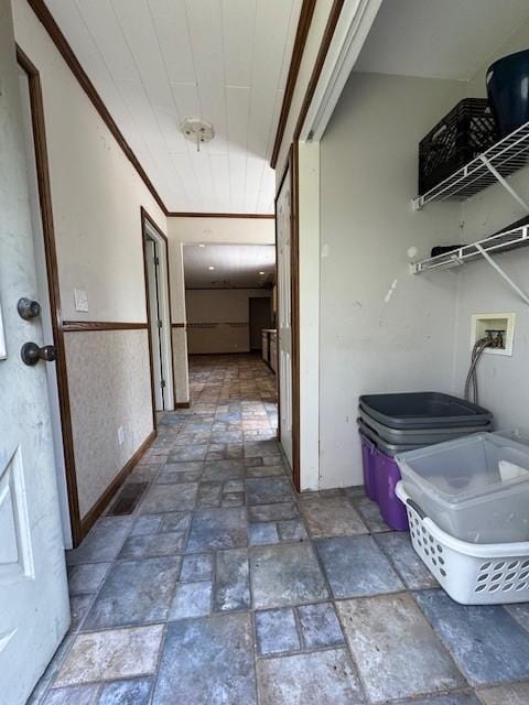 hall featuring visible vents, stone tile flooring, and wainscoting