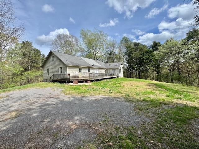 view of property exterior with a wooden deck
