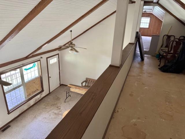interior space with a ceiling fan and lofted ceiling with beams