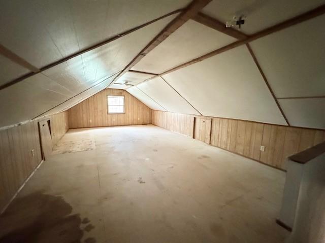 bonus room featuring wooden walls and lofted ceiling