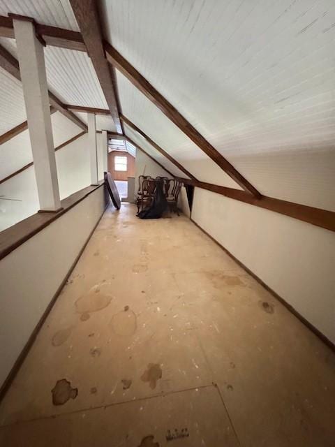 additional living space with vaulted ceiling with beams