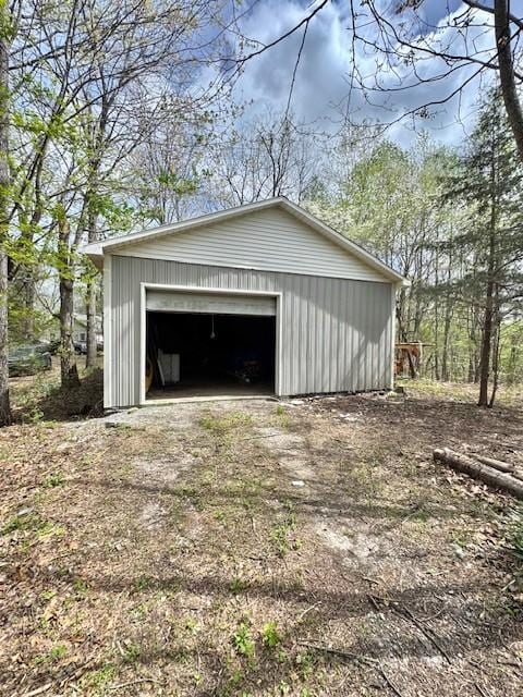 detached garage featuring dirt driveway