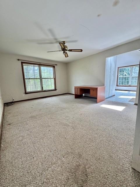 unfurnished living room with a ceiling fan and light colored carpet