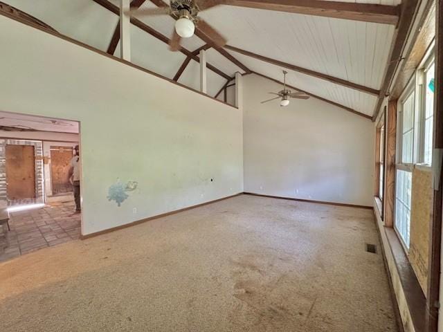 carpeted spare room with high vaulted ceiling, ceiling fan, baseboards, and beam ceiling