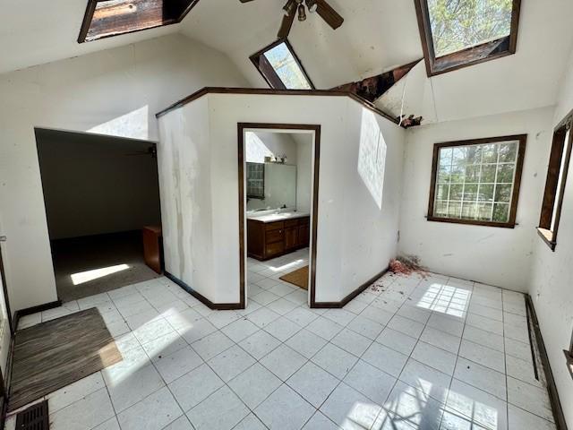 bonus room featuring a sink, ceiling fan, and lofted ceiling with skylight
