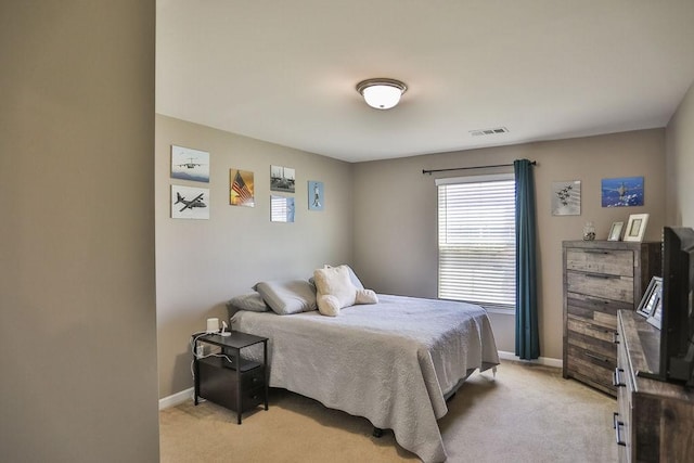 bedroom with visible vents, baseboards, multiple windows, and light colored carpet