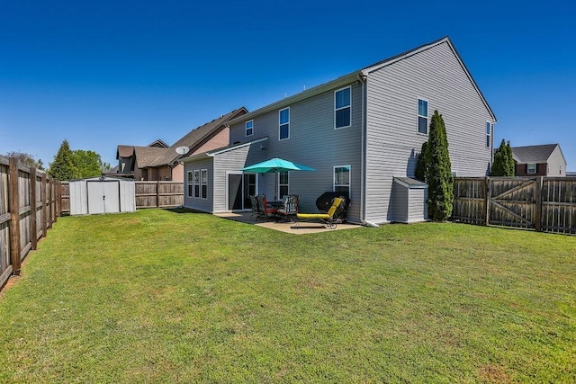 rear view of house with a shed, a yard, a fenced backyard, an outdoor structure, and a patio