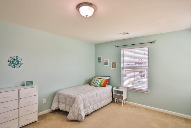 bedroom featuring visible vents, baseboards, and light colored carpet