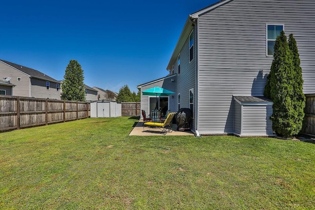 view of yard with a patio area, a fenced backyard, an outdoor structure, and a shed