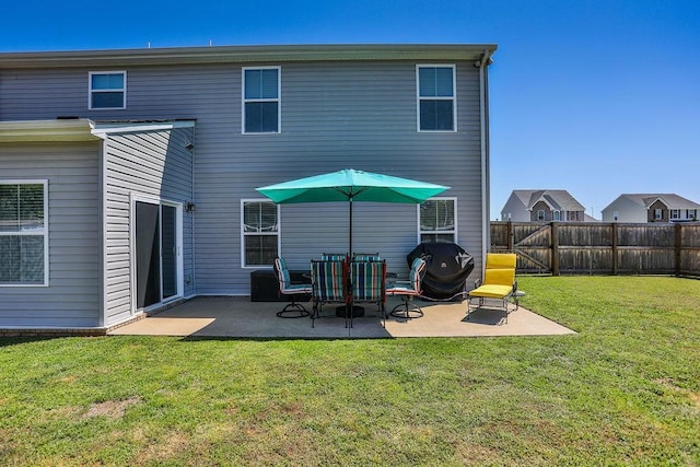 rear view of property with a patio area, fence, and a yard