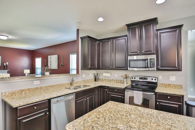 kitchen with dark brown cabinetry, a sink, and stainless steel appliances