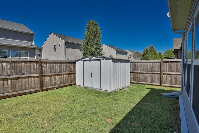 view of yard featuring a storage unit, a fenced backyard, and an outdoor structure