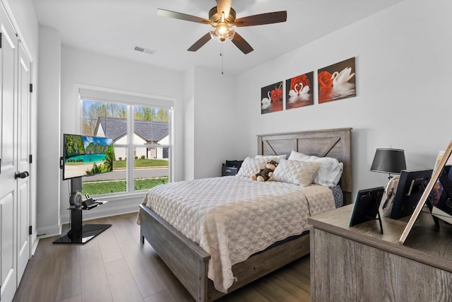 bedroom with visible vents, baseboards, a ceiling fan, and wood finished floors