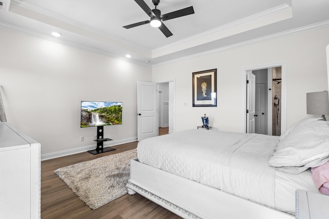 bedroom featuring baseboards, ornamental molding, a ceiling fan, a tray ceiling, and wood finished floors