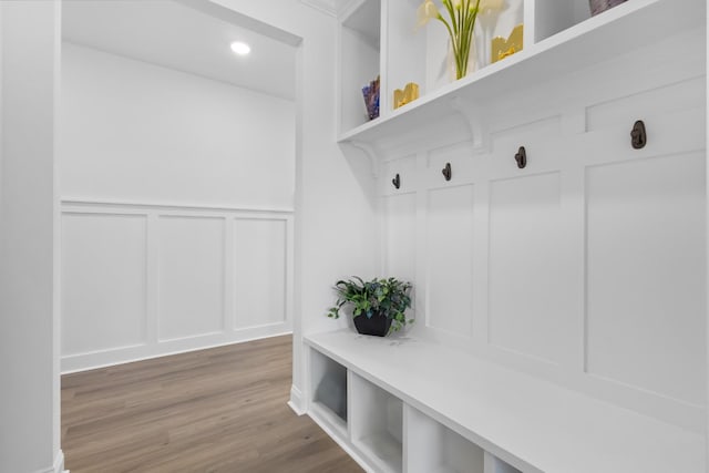 mudroom featuring a decorative wall, recessed lighting, and wood finished floors