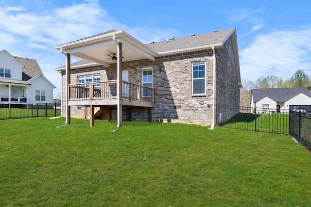 rear view of house featuring brick siding, a fenced backyard, a deck, and a lawn