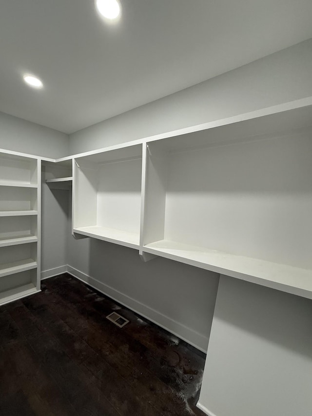 walk in closet with visible vents and dark wood finished floors